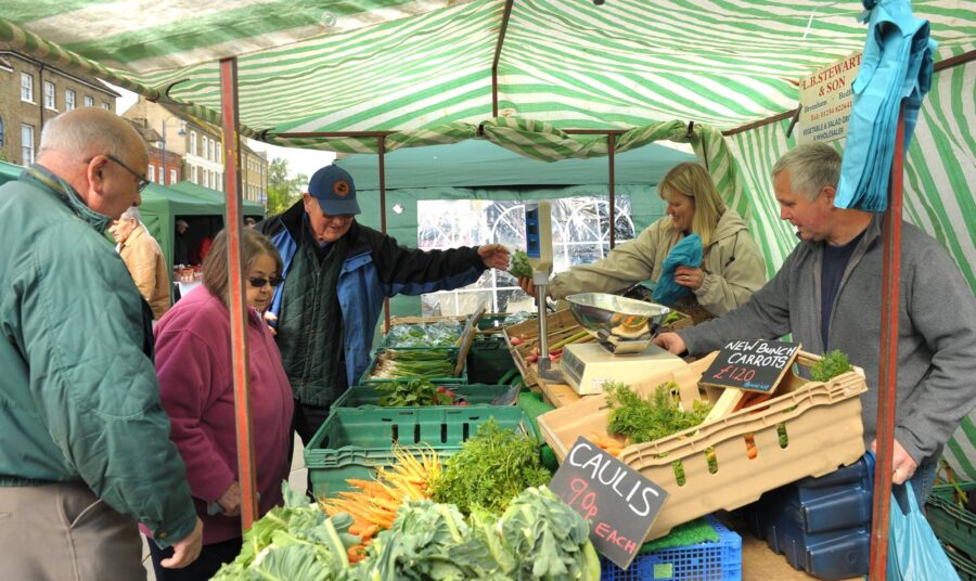The image shows a lively scene at a local market